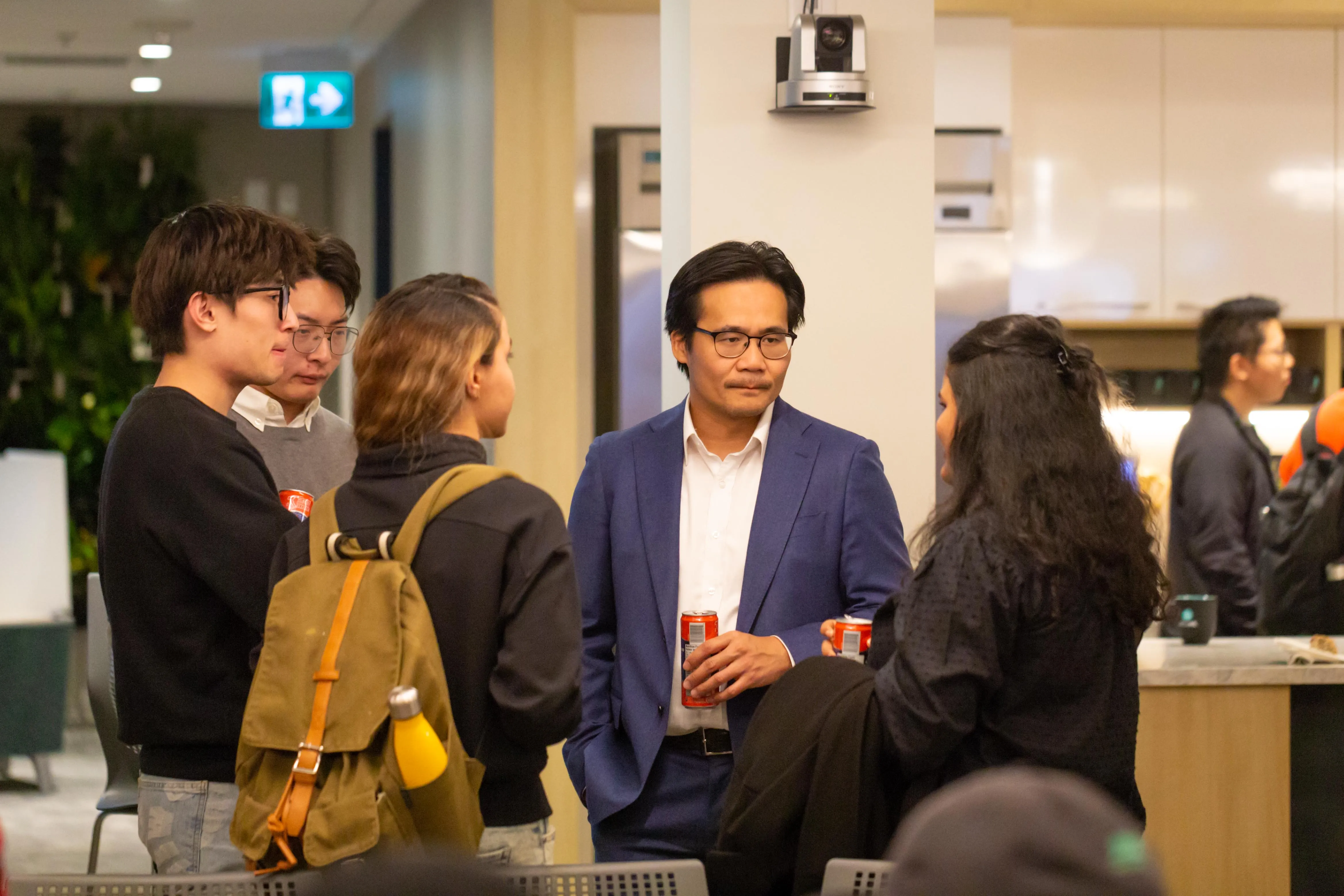 A group of people standing in a circle, talking to each other.